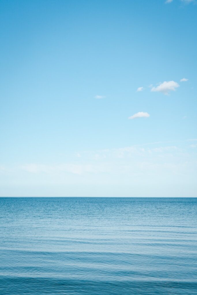 A large body of water sitting under a blue sky